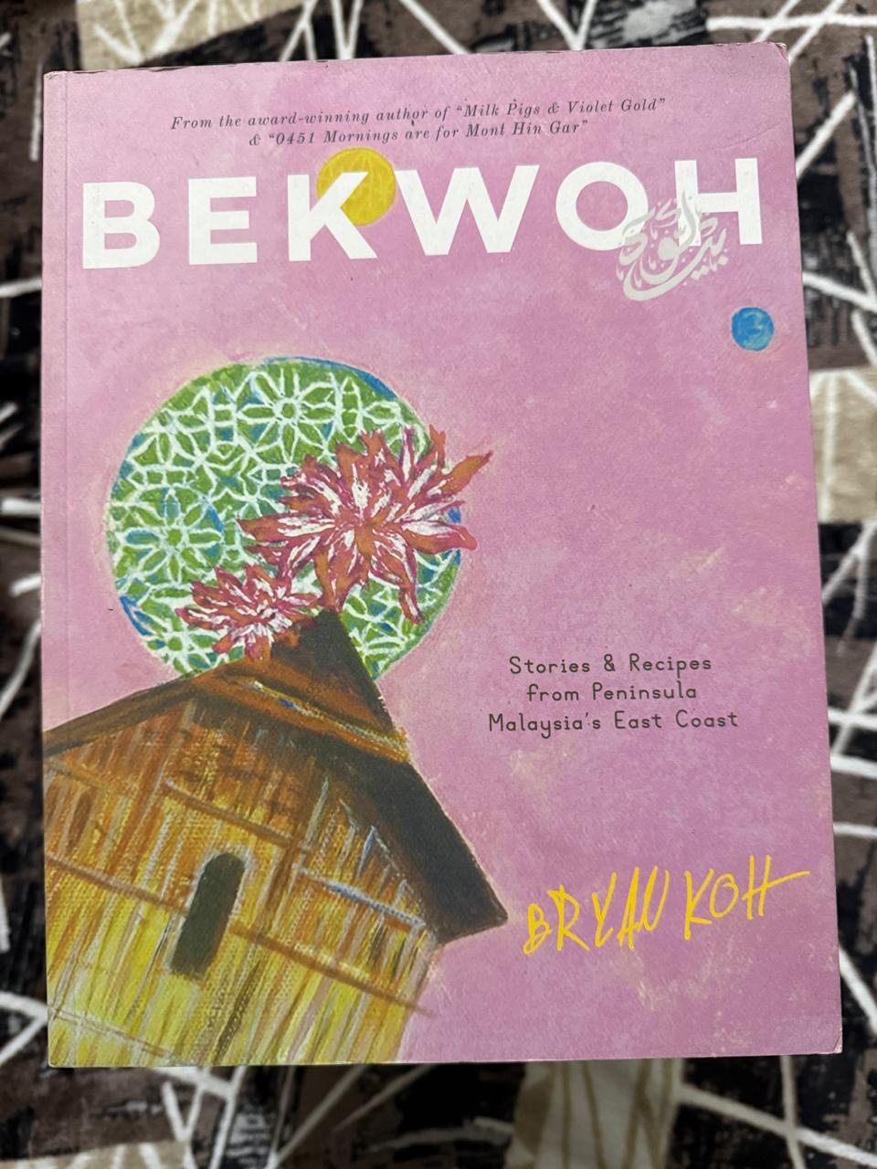 Used Book - BEKWOH - Stories & Recipes from Peninsula Malaysia's East Coast - Bryan Koh - From The Award Winning Author of " Milk Pigs & Violet Gold " and " 0451 Mornings are from Mont Hin Gar " - Bekwoh unfolds as a culinary journey along Malaysia’s East Coast — from Terengganu’s fishing villages, where keropok lekor is crafted by hand, to Kota Bharu’s bustling central market, alive with an irresistible array of kuih. The trail continues north to Tumpat for khao jam, then south to Pahang, where roadside stalls dish out smoky lemang and rich rendang. Along the way, it weaves in the everyday and celebratory dishes of the Peranakan Chinese communities of Kelantan and Terengganu. Rooted in an East Coast word for cooking vessels, Bekwoh has come to symbolize generosity, abundance, and shared joy. These are the qualities Bryan brings to the table, offering more than 100 recipes that celebrate food as a source of warmth, culture, and togetherness.