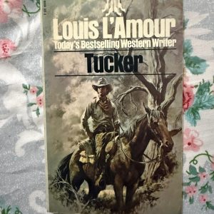 Second hand Book - Louis L'Amour - TUCKER - Louis L’Amour’s Tucker is a gritty, masterfully crafted Western that embodies the rugged spirit of the frontier. Through Shell Tucker’s relentless determination, L’Amour weaves a gripping tale of honor, survival, and justice. It is a lean, evocative classic that captures the raw beauty of the Old West with unmatched authenticity.