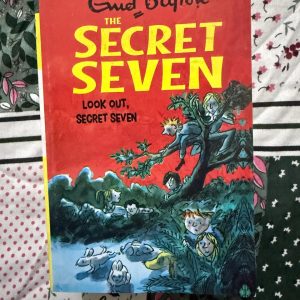 Used Book - Enid Blyton - Look Out, Secret Seven - Hachette India - Look Out, Secret Seven is a suspenseful gem that perfectly captures the thrill of a stakeout. When a simple request to find a missing dog spirals into a dangerous encounter with dog thieves, Blyton delivers high-stakes excitement. It’s a classic tale of bravery, reminding us that no mystery is too small for a determined team.