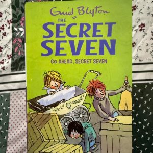 Used Book - Enid Blyton - Go Ahead Secret Seven - Hachette India - In Go Ahead Secret Seven, Blyton showcases the group’s unwavering grit. When a simple shadowing exercise spirals into a genuine coal-yard conspiracy, the stakes feel refreshingly real. It’s a dynamic adventure that highlights the importance of staying alert, proving that even the smallest clue can lead to a massive win.