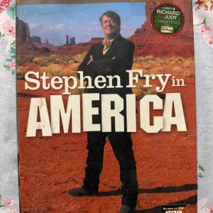 Used Book - Stephen Fry in America - As Seen on BBC - Harper Collins - Hardbound - This premium hardbound HarperCollins edition of Stephen Fry in America is a delightful, witty masterpiece. Accompanying the hit BBC series, Fry’s signature charm, warmth, and keen intellect shine through as he explores all fifty states. It’s an insightful, beautifully packaged travelogue that captures the true, diverse heart of America.
