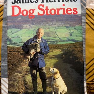 Used Book - James Herriot's Dog Stories - with Illustrations by Victor Ambrus (Hardbound) - This beautiful hardbound collection is a must-have for any animal lover. Victor Ambrus’s evocative illustrations perfectly complement James Herriot’s warm, humorous, and deeply touching tales. It is a timeless, heartwarming tribute to the special bond between humans and their dogs—a true classic that belongs on every reader’s bookshelf.