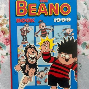 Used Book - The BEANO Annual - 1999 - A Mischievous World of Beano - The Beano Annual 1999 is a riotous celebration of timeless British comic genius. Packed with vibrant, chaotic mischief from Dennis the Menace, Desperate Dan, and the gang, it delivers pure nostalgic joy. Clever, brilliantly illustrated, and effortlessly funny, this classic treasure remains an absolute must-read for pranksters of all ages!