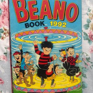 Used Book - The BEANO Annual - 1992 - A Mischievous World of Beano - The Beano Annual 1992 is an explosive vault of pure comic brilliance. Overflowing with iconic, rebellious capers from Dennis the Menace, Roger the Dodger, and favorite mischief-makers, it captures the golden age of chaotic fun. Brilliantly illustrated and endlessly witty, this nostalgic treasure is an absolute delight for readers everywhere!